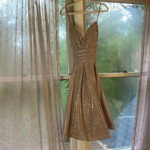Champagne dress, mid length, v-neck, strap back, good condition, padding.